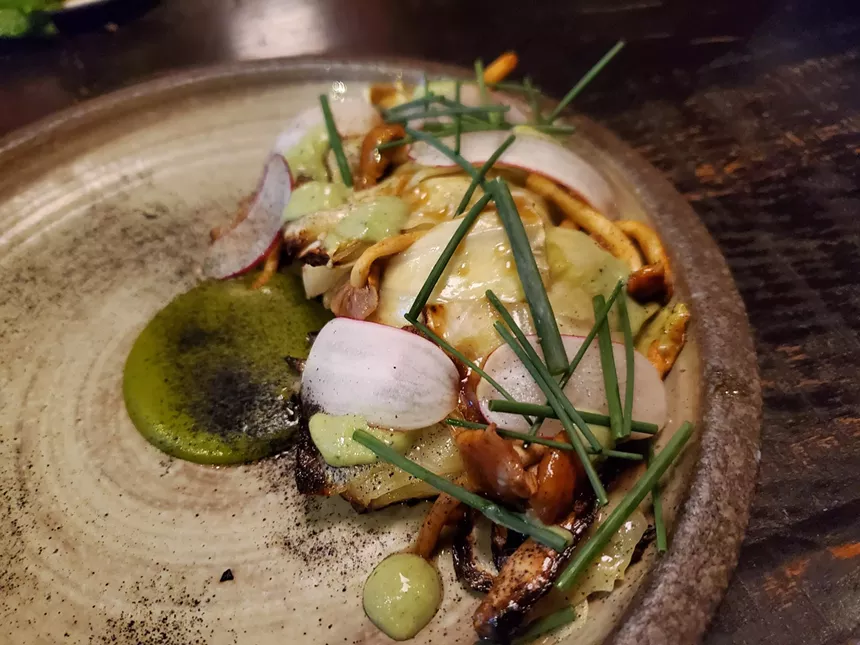 cabbage, radish and chives on a plate with green sauce