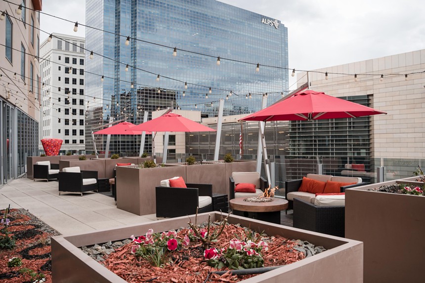 Comfortable seating and red umbrellas on Fire Restaurant's rooftop patio