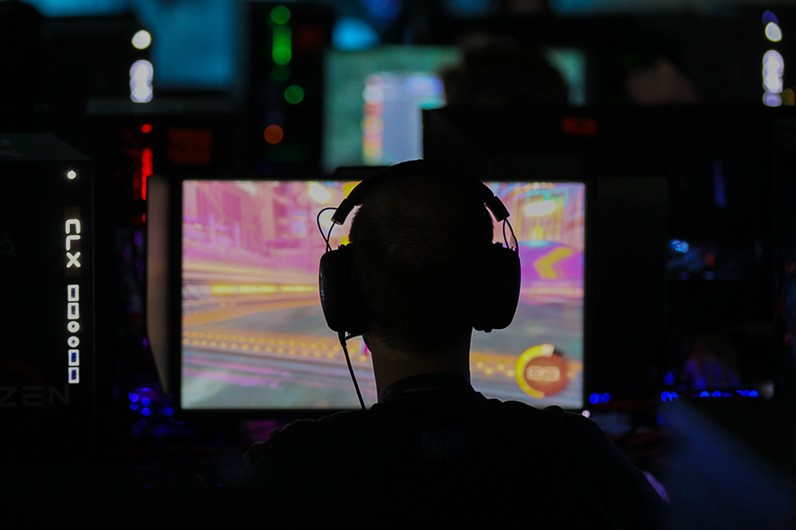 Man in headphones plays video games in the dark