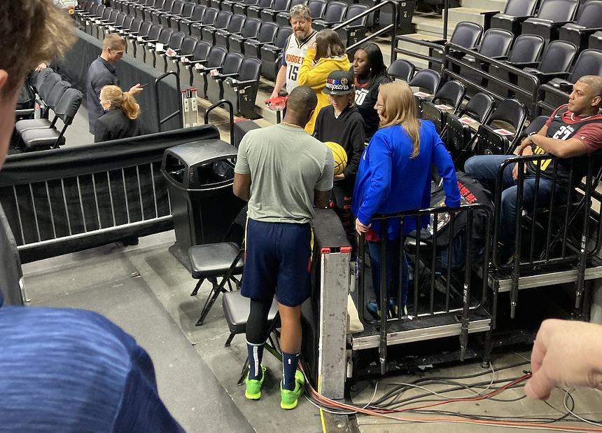 Denver Nuggets super fan Vicki Ray with other fans greeting a player.