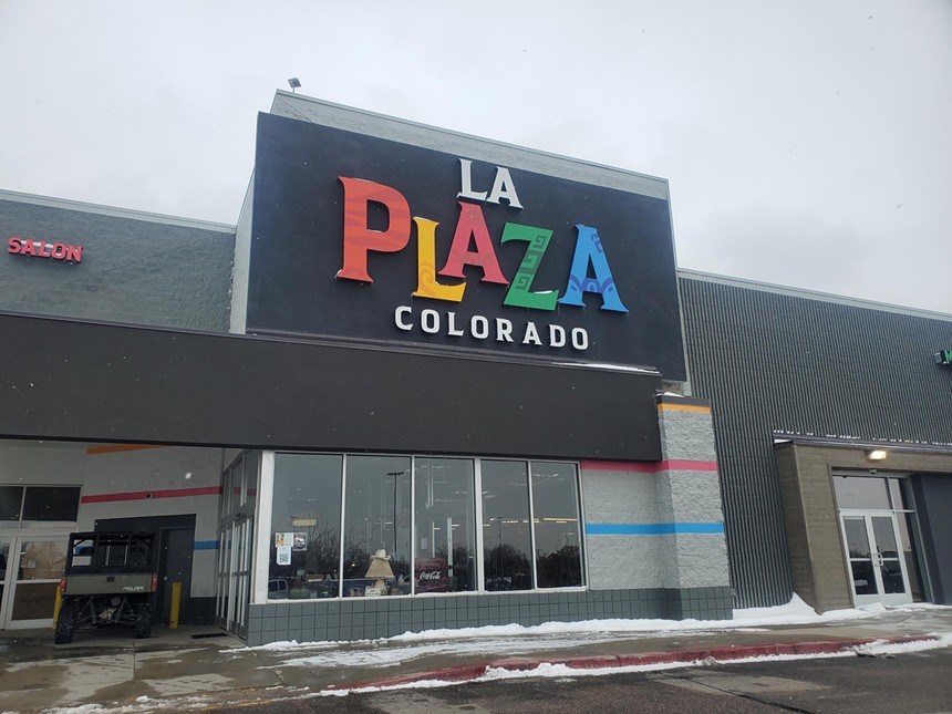 front of a building with a colorful "la plaza" sign