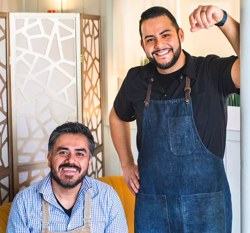 two men in aprons posing