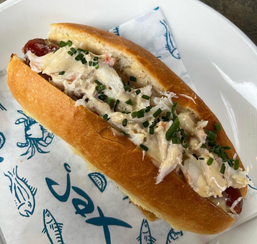 a hot dog topped with crab