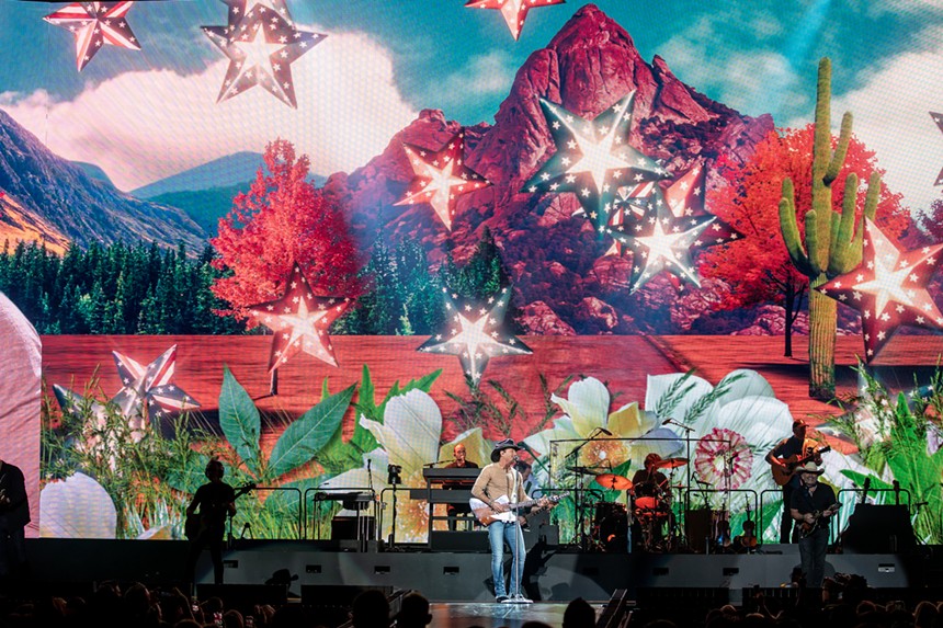 country band on stage with a background of mountains and stars