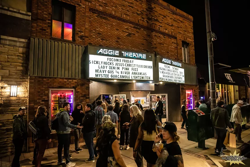 people standing outside a music venue