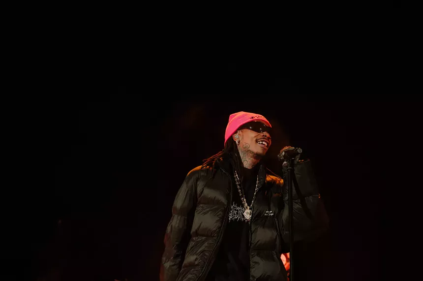 man in apink beanie at a microphone