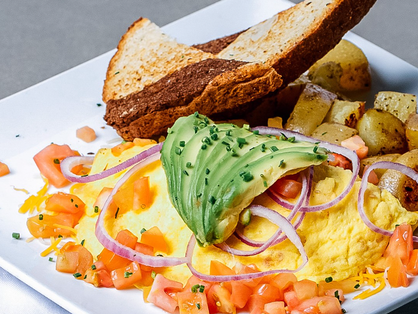toast, home fries and eggs topped with avocado, diced tomatoes, red onion