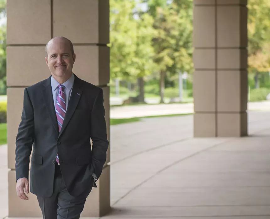 District Attorney Brian Mason standing and smiling.