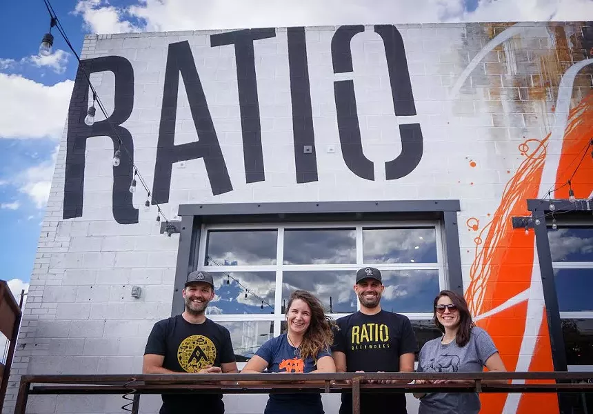 Brewery facade with people standing behind a railing out front.
