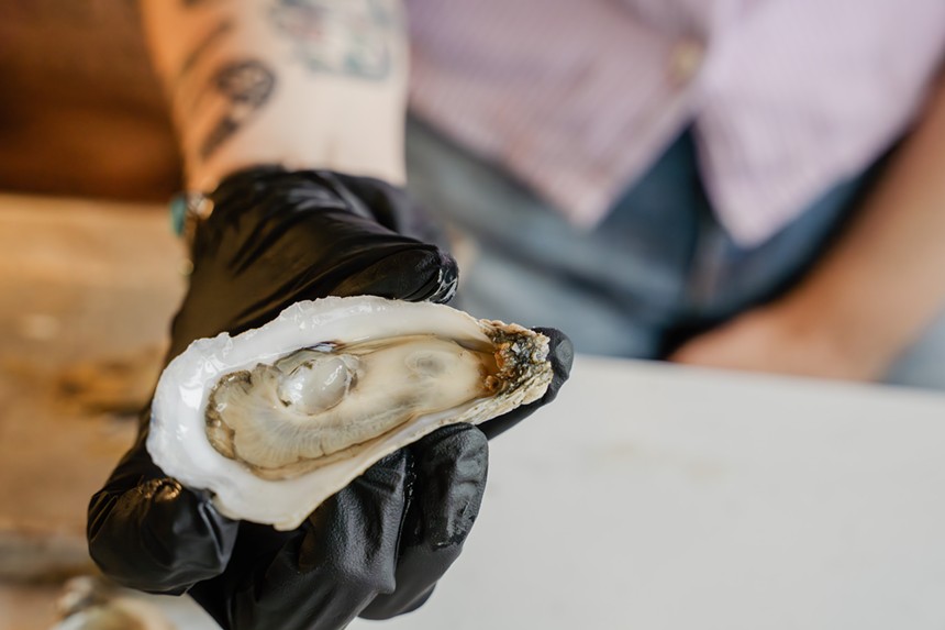 hand holding a shucked oyster