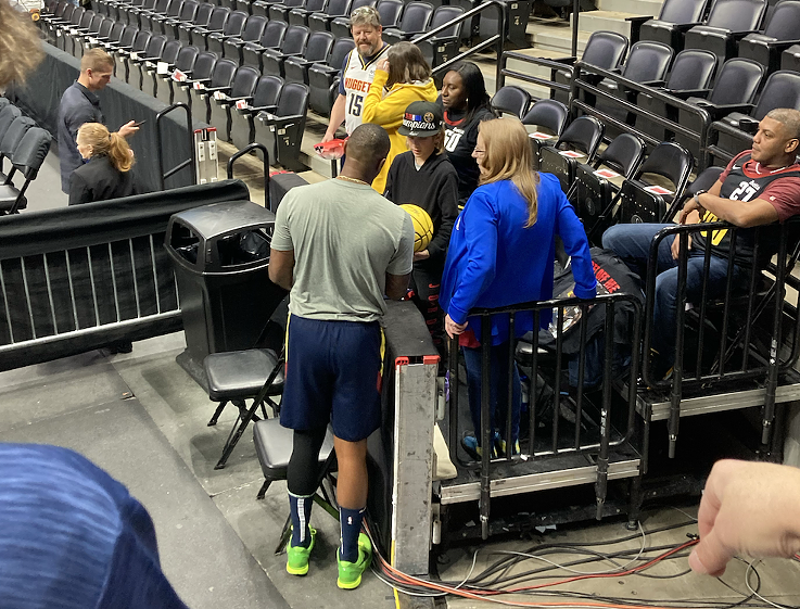 Denver Nuggets super fan Vicki Ray with other fans greeting a player.