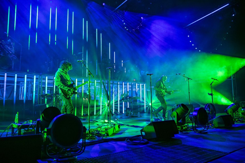 band performing on stage with blue and green lights