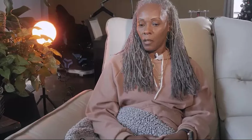A woman sitting in a chair and speaking.