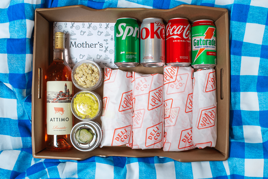 Four sandwiches and sides, canned drinks and a bottle of wine packaged by Leven Deli Co.