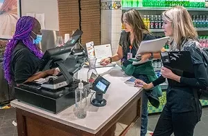 Three people talking to each other inside a store.