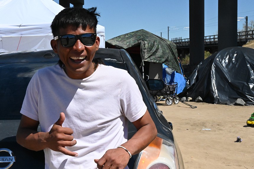 A migrant lives at an encampment.