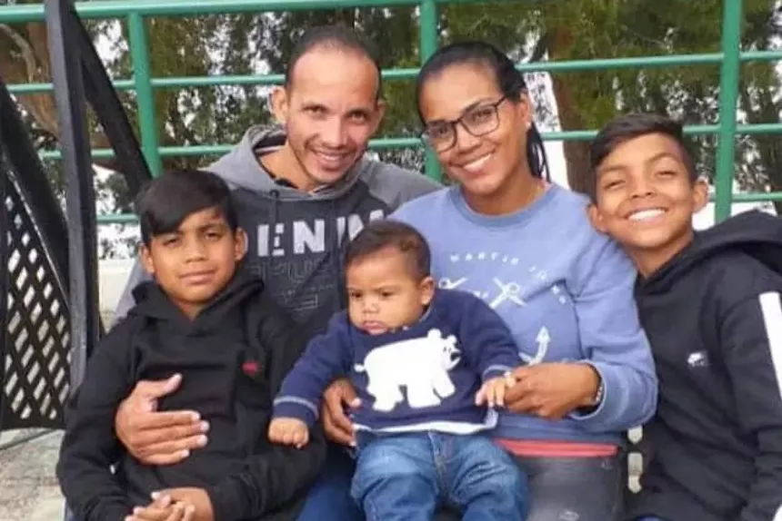 A migrant poses with his family in Venezuela.
