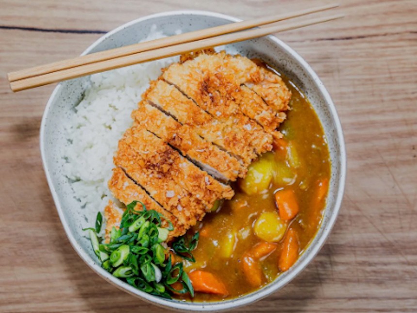 a fried pork cutlet with rice and curry