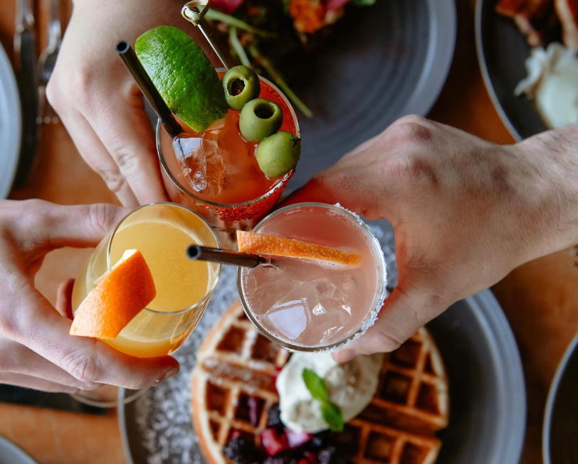 hands holding various cocktails