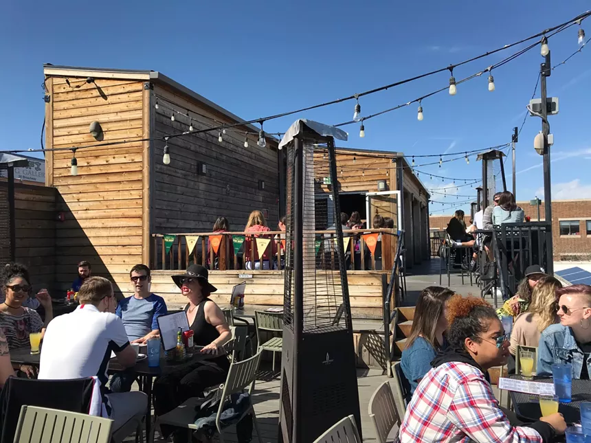 people sitting on a rooftop patio