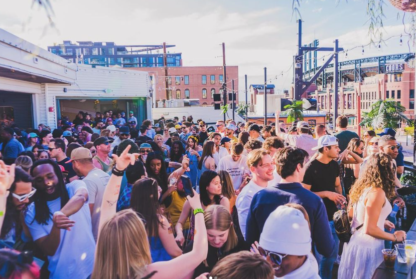 a large crowd of people on a rooftop patio