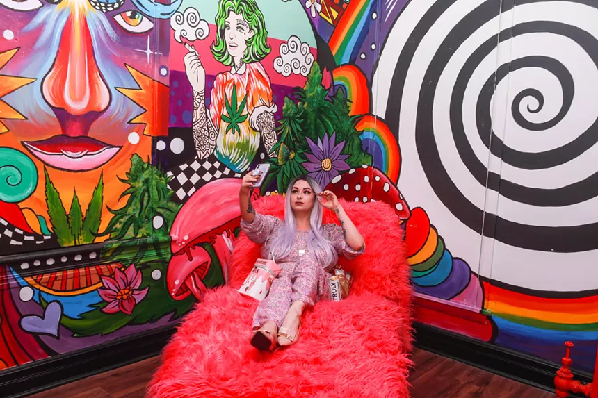 Woman takes a selfie in front of indoor mural