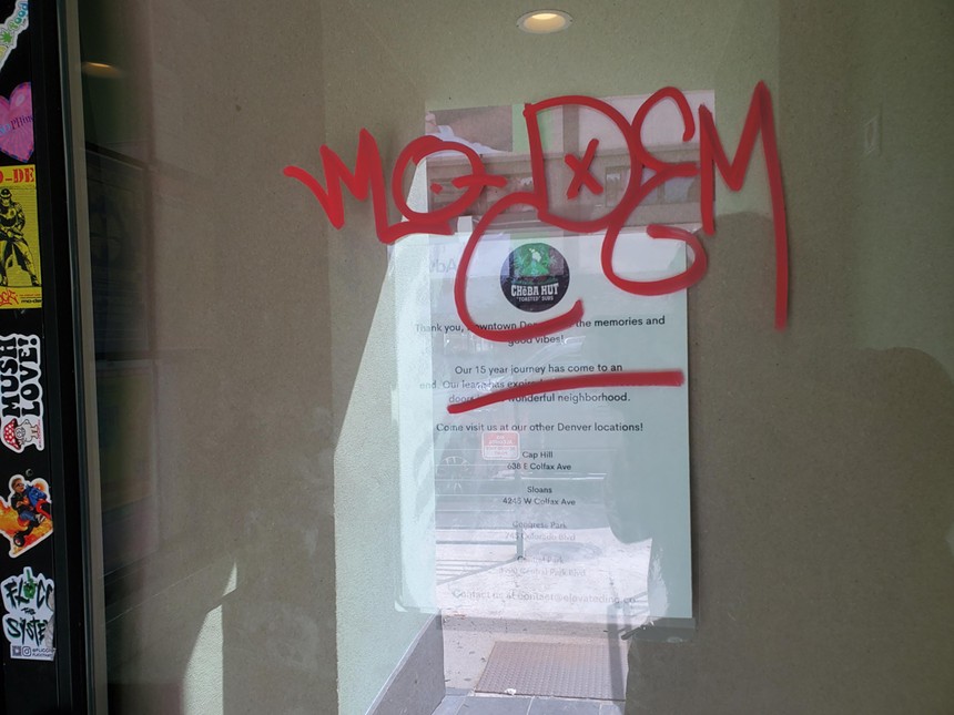 a note on a glass door covered in red graffiti