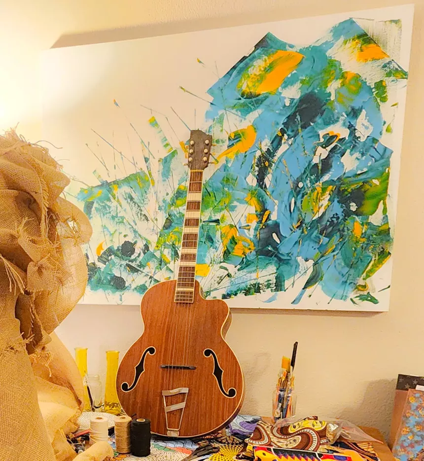 guitar leaning on a wall with crafting tools