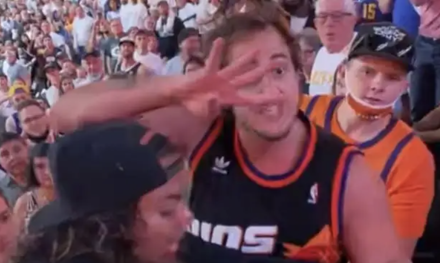A man at a basketball game taunting others.