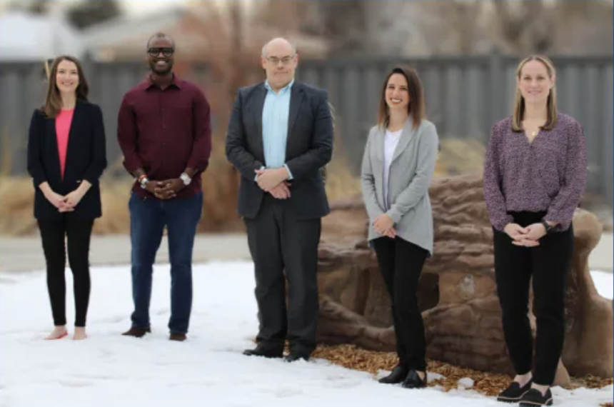 A group of people standing around in the snow.