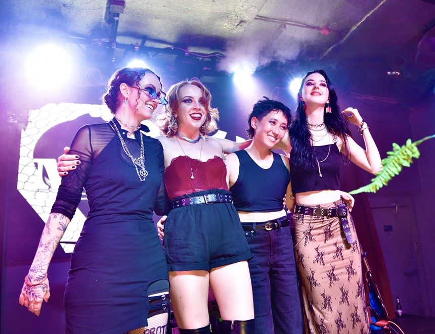 four women musicians smiling on stage