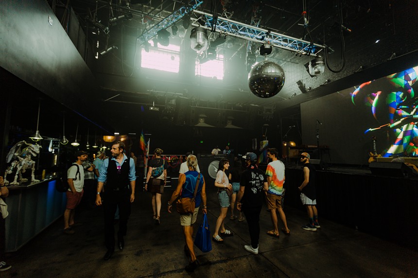 People dance under disco ball indoors