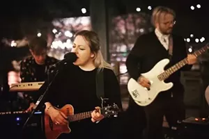 woman singing and playing guitar