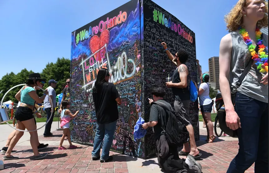 a black cube art installation that people are drawing on with chalk