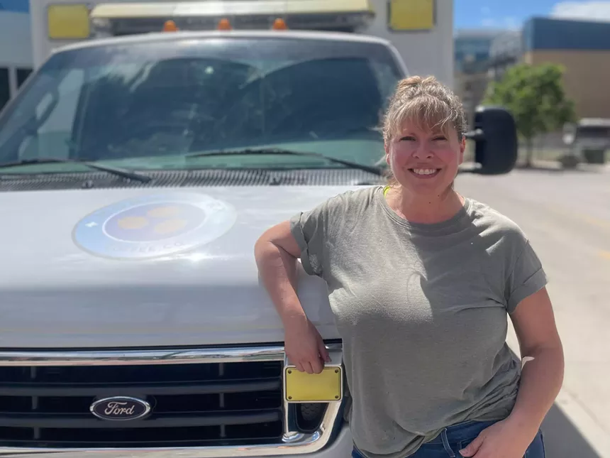 woman posting in front of an ambulance