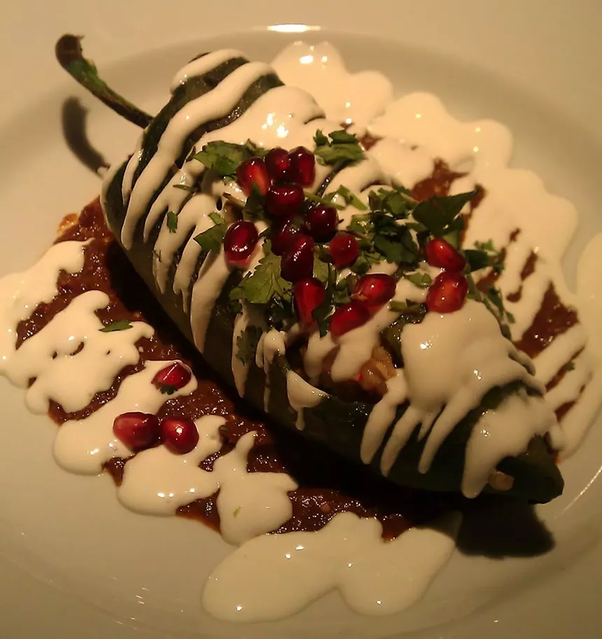 a chile covered in white and red sauce