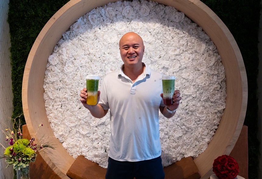 a man holding two matcha drinks