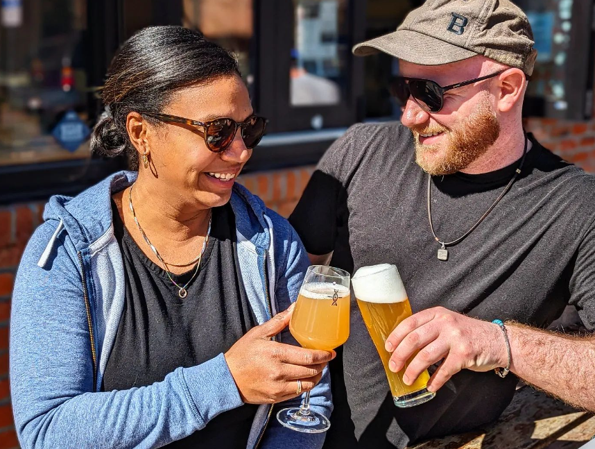 two people clinking glasses of beer