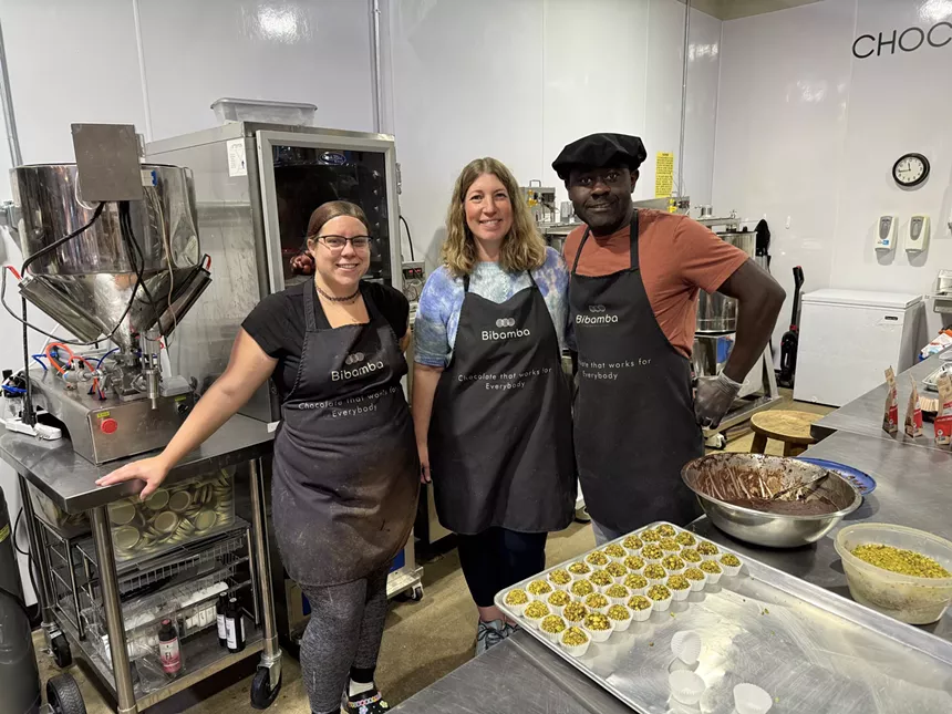 three people in black aprons posing