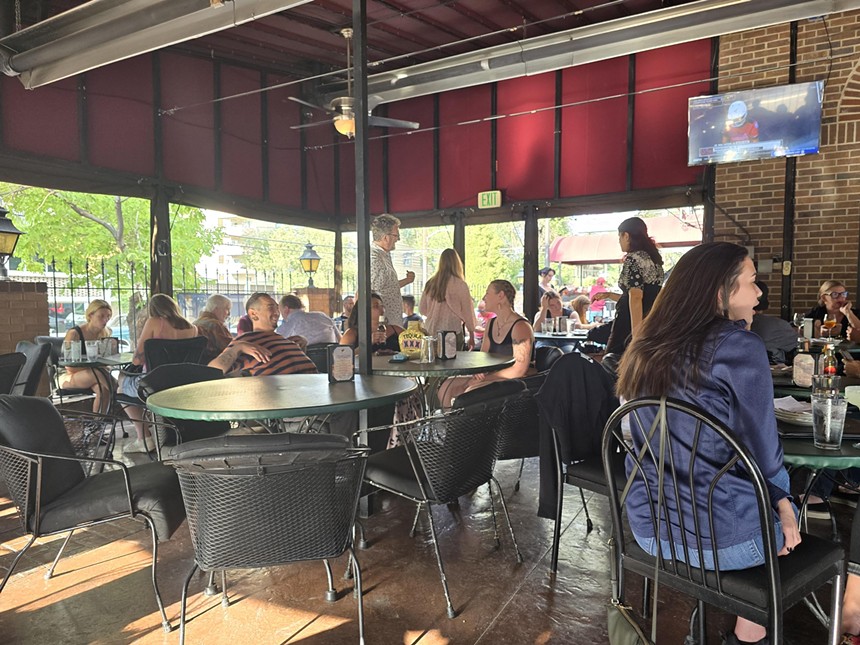people sitting at tables on a patio