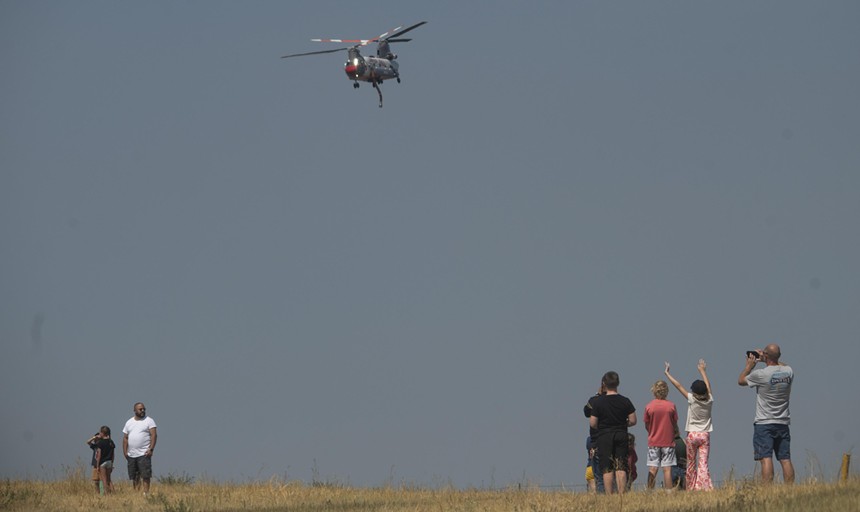 Water tanker helicopter flies in front of cheering crowd