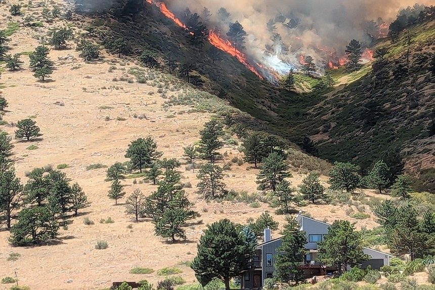 A wildfire heads towards a house.