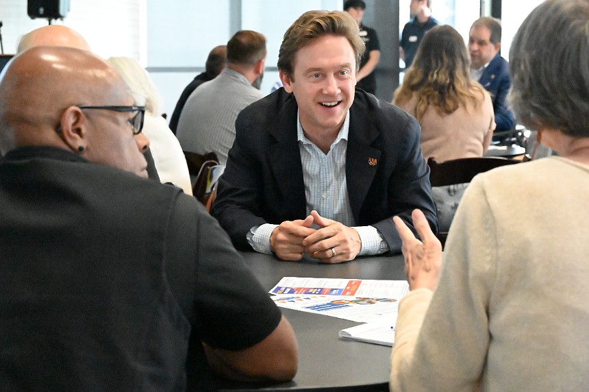 A man smiles while talking to a woman