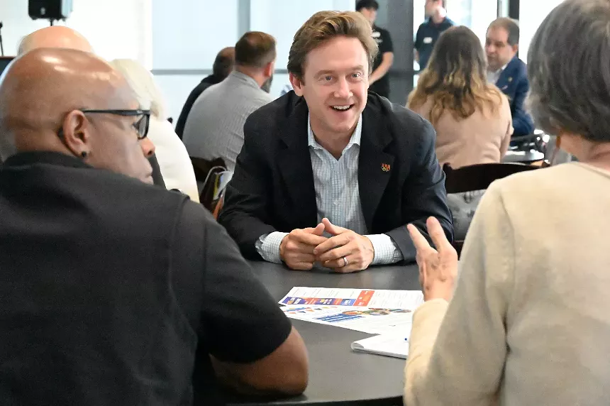 A man smiles while talking to a woman