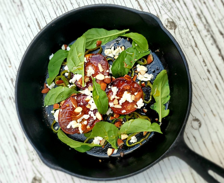 cast iron skillet with peaches and arugula