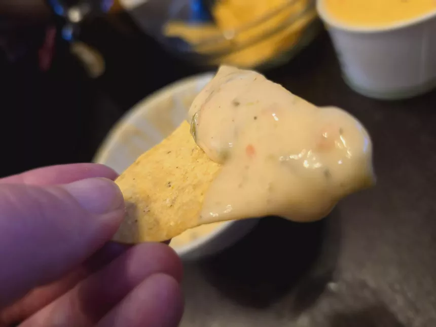 a chip dipped in queso