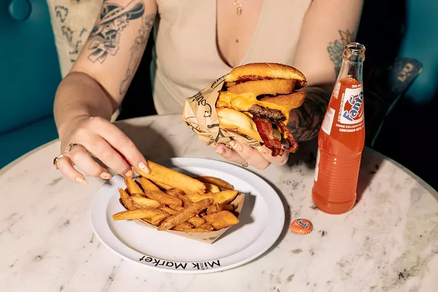 person eating french fries and a burger