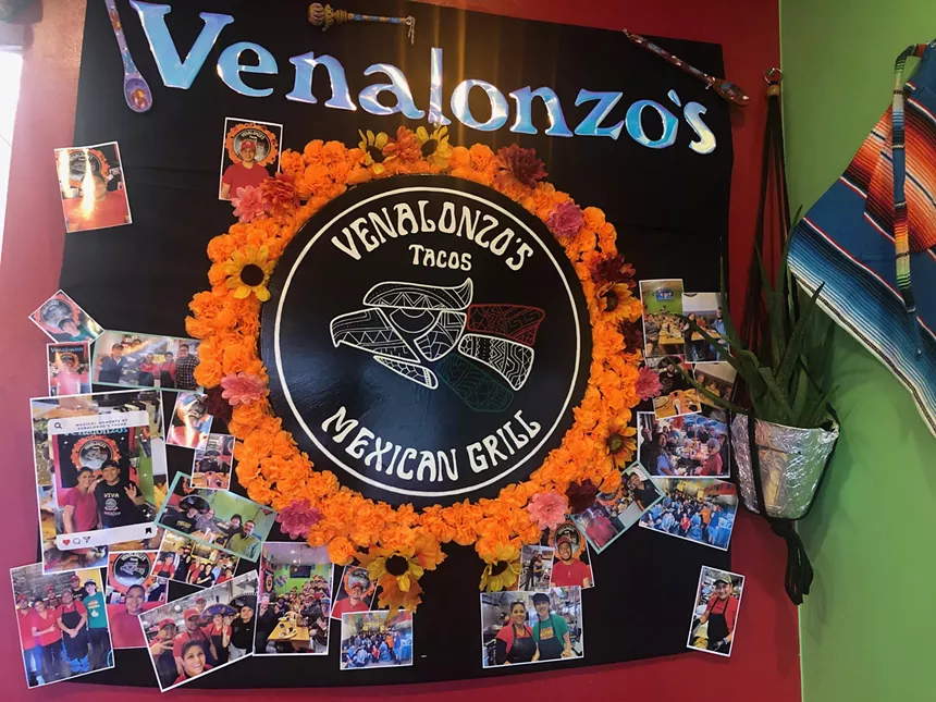 a sign on a wall with photos attached to it