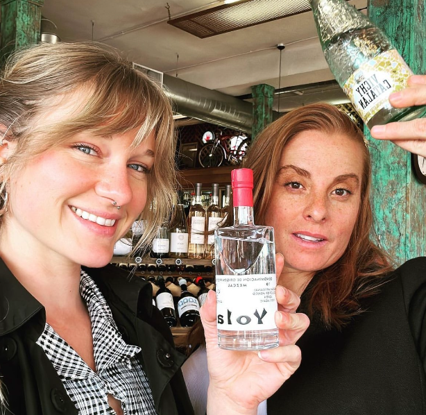 two women holding bottles of alchohol