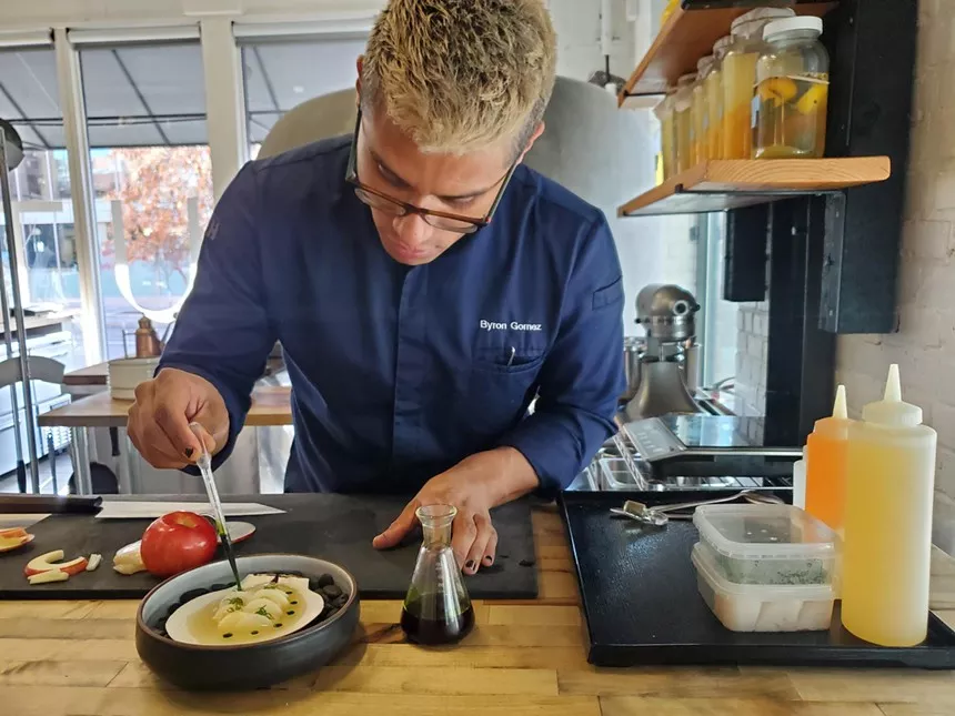man in a chef's coat plating food